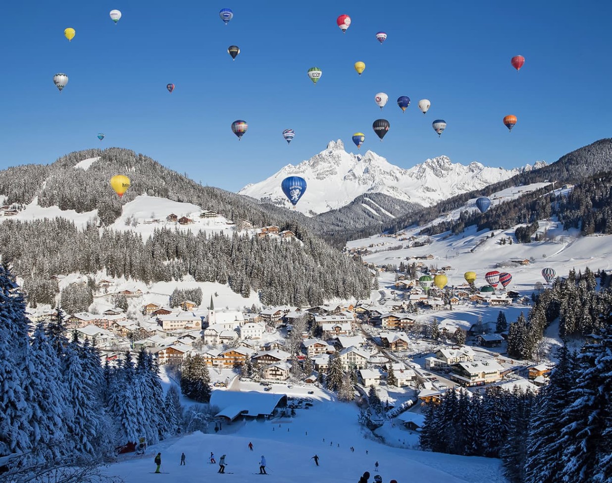 Blick von der Skipiste der Papagenobahn auf Filzmoos während der Ballonwoche